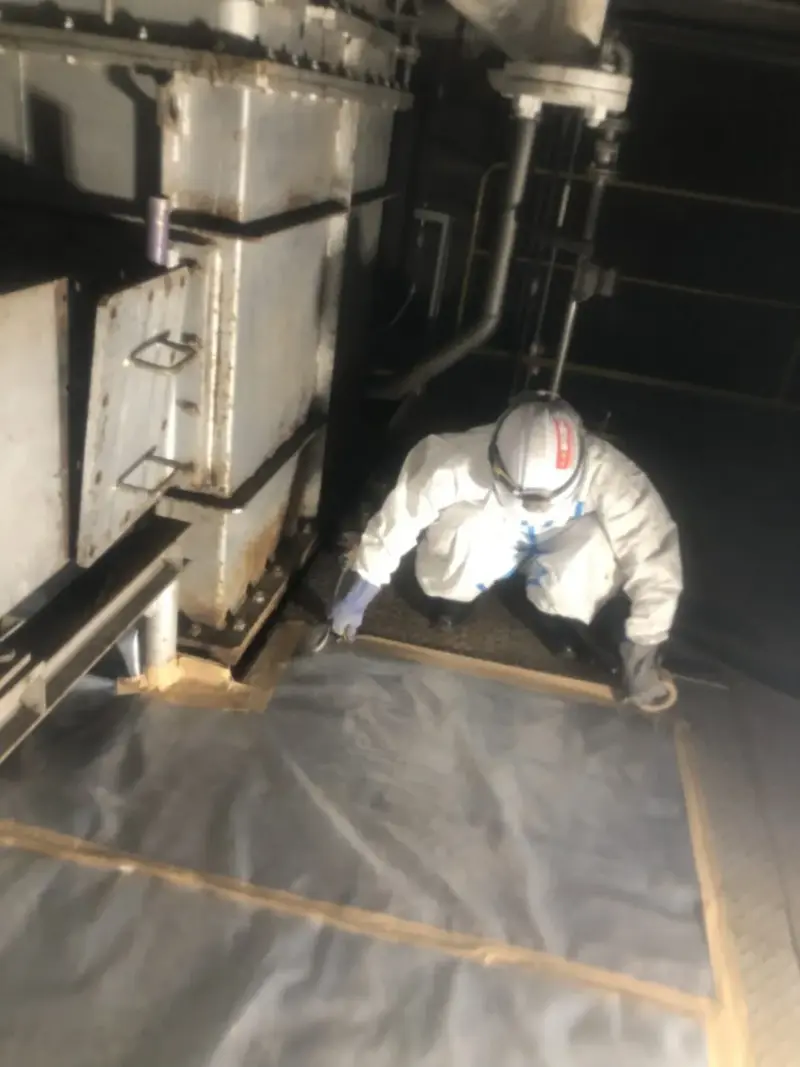 隔離した機械室で除去作業をする作業員