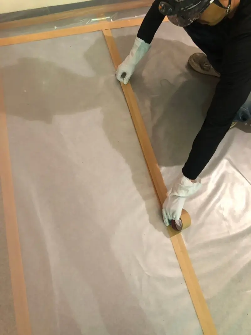 シートとテープで隔離養生する作業員