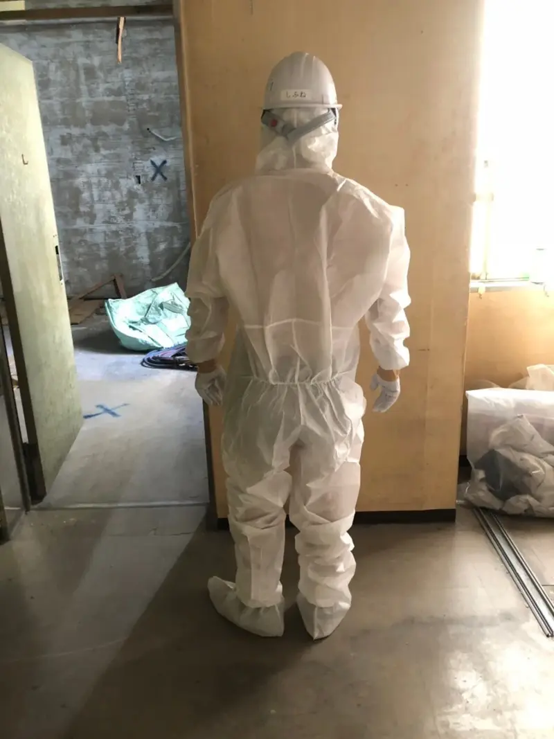 防護服と防じんマスクを着用した作業員
